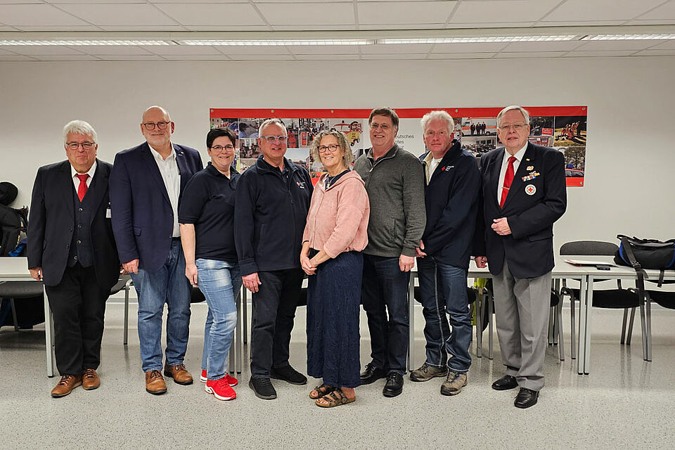 Sechs Männer und zwei Frauen stehen im DRK Gebäude in Soest in einer Gruppe nebeneinander für ein Foto.